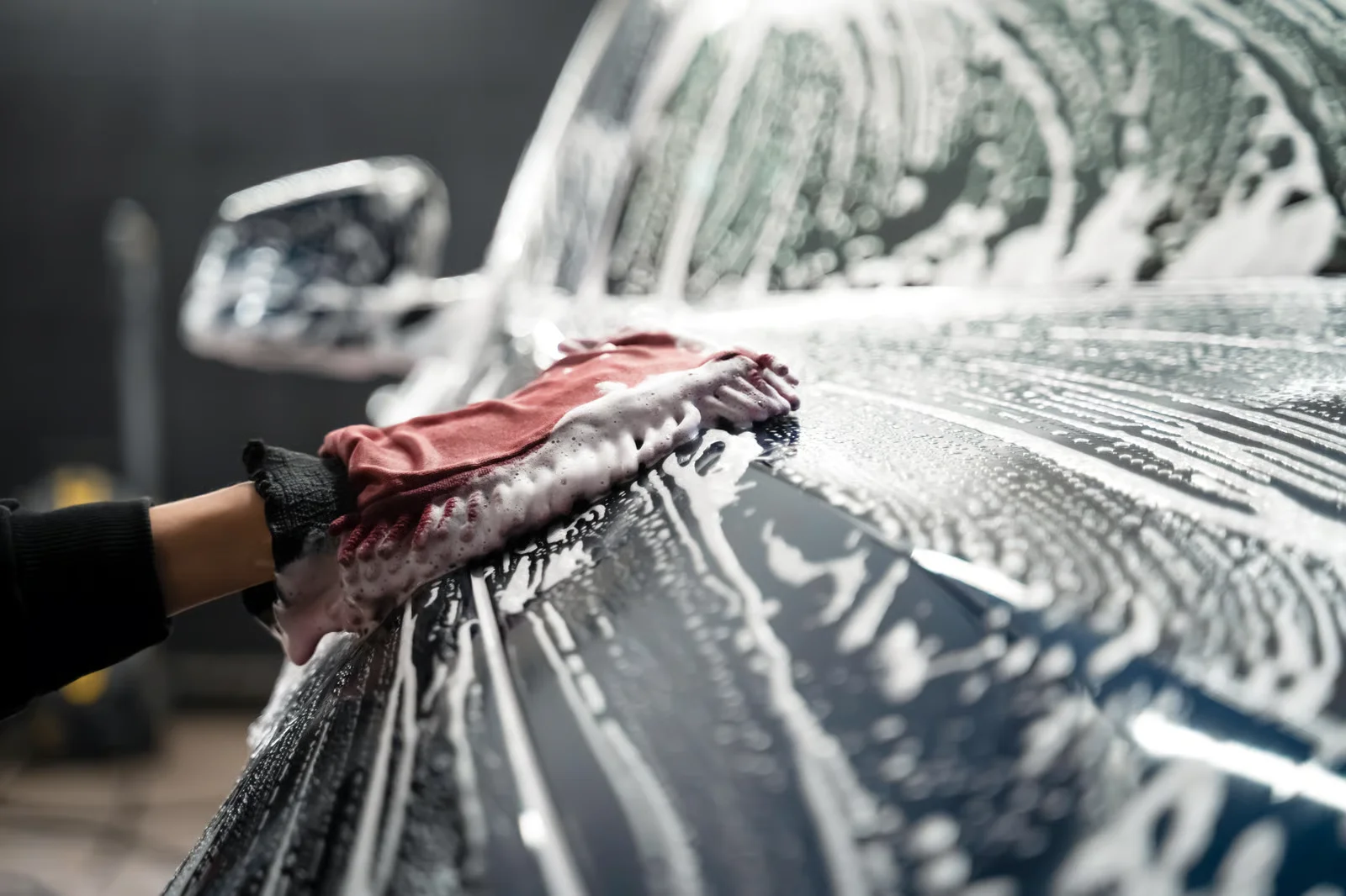 detailing specialist hand washing the exterior of a car