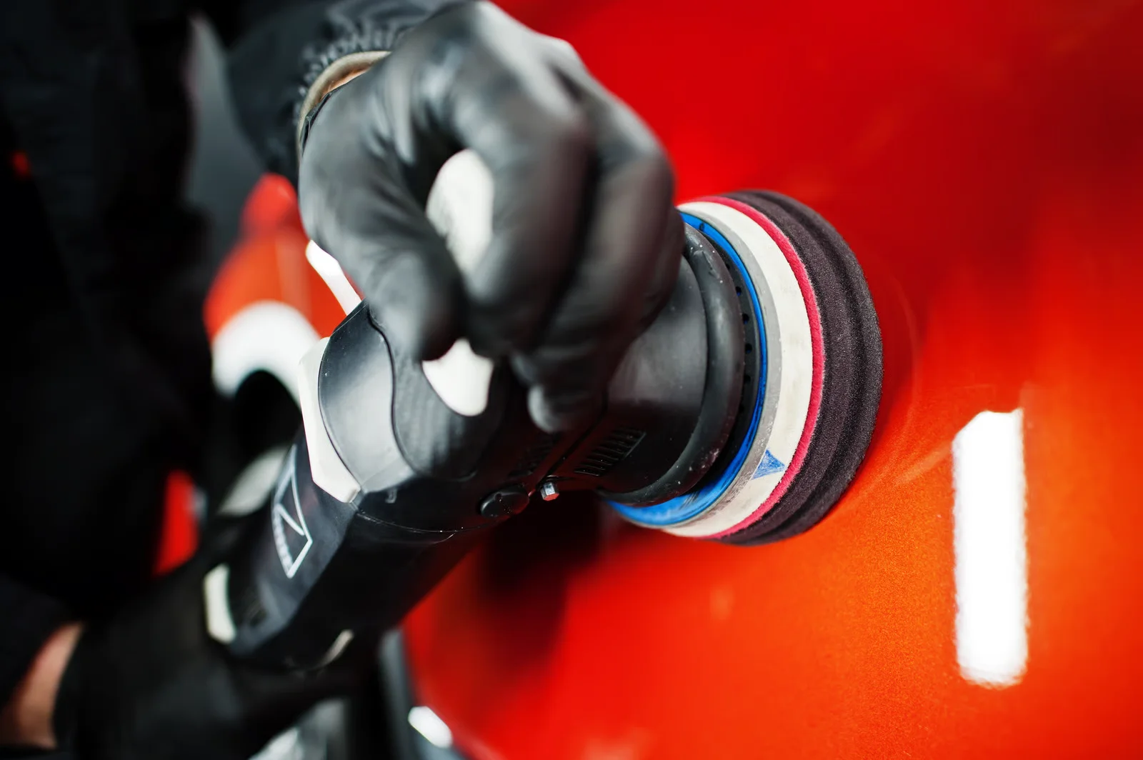 technician polishing the paint job with a special tool for paint correction