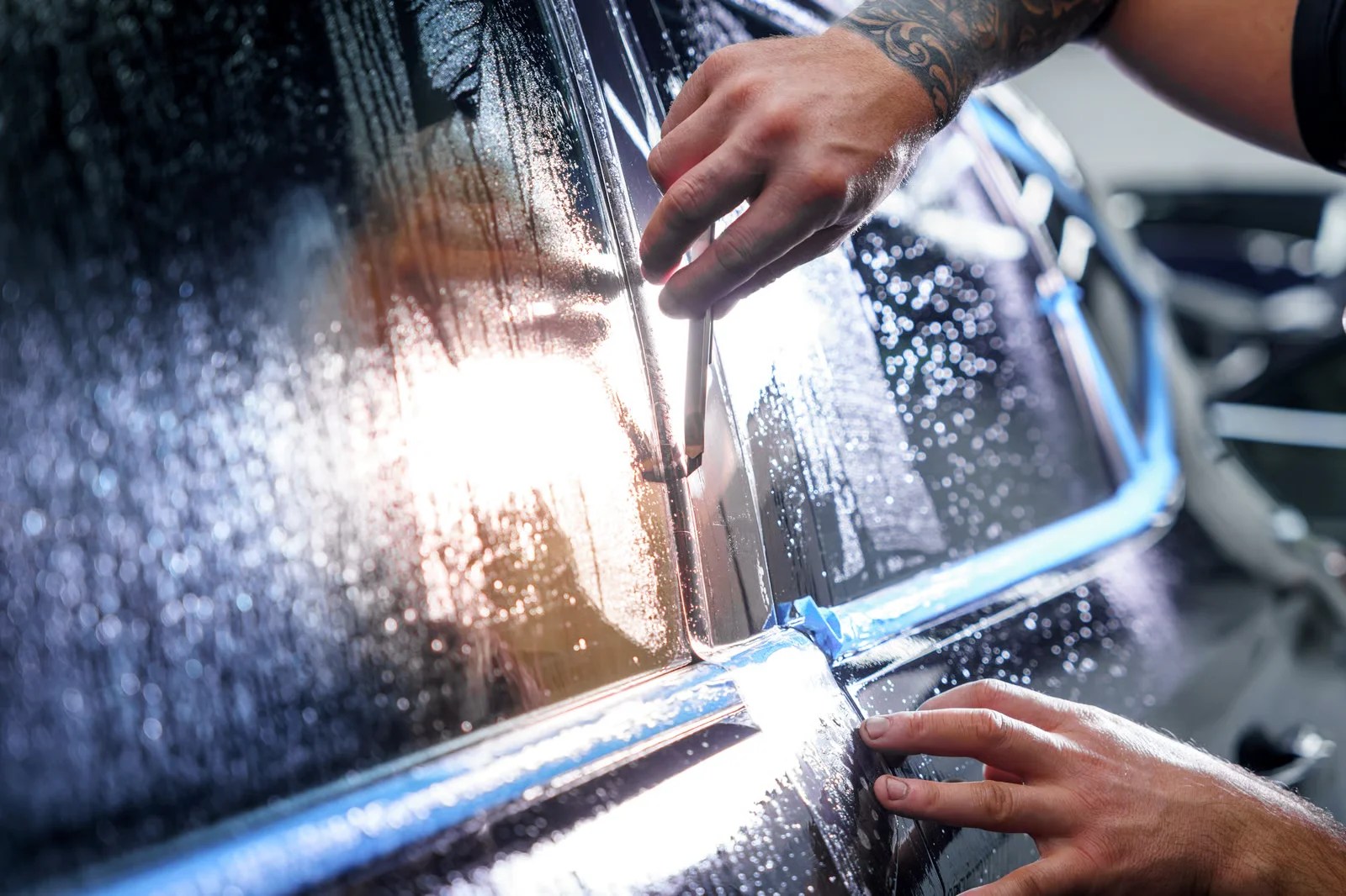 detailing technician coating the exterior of a vehicle
