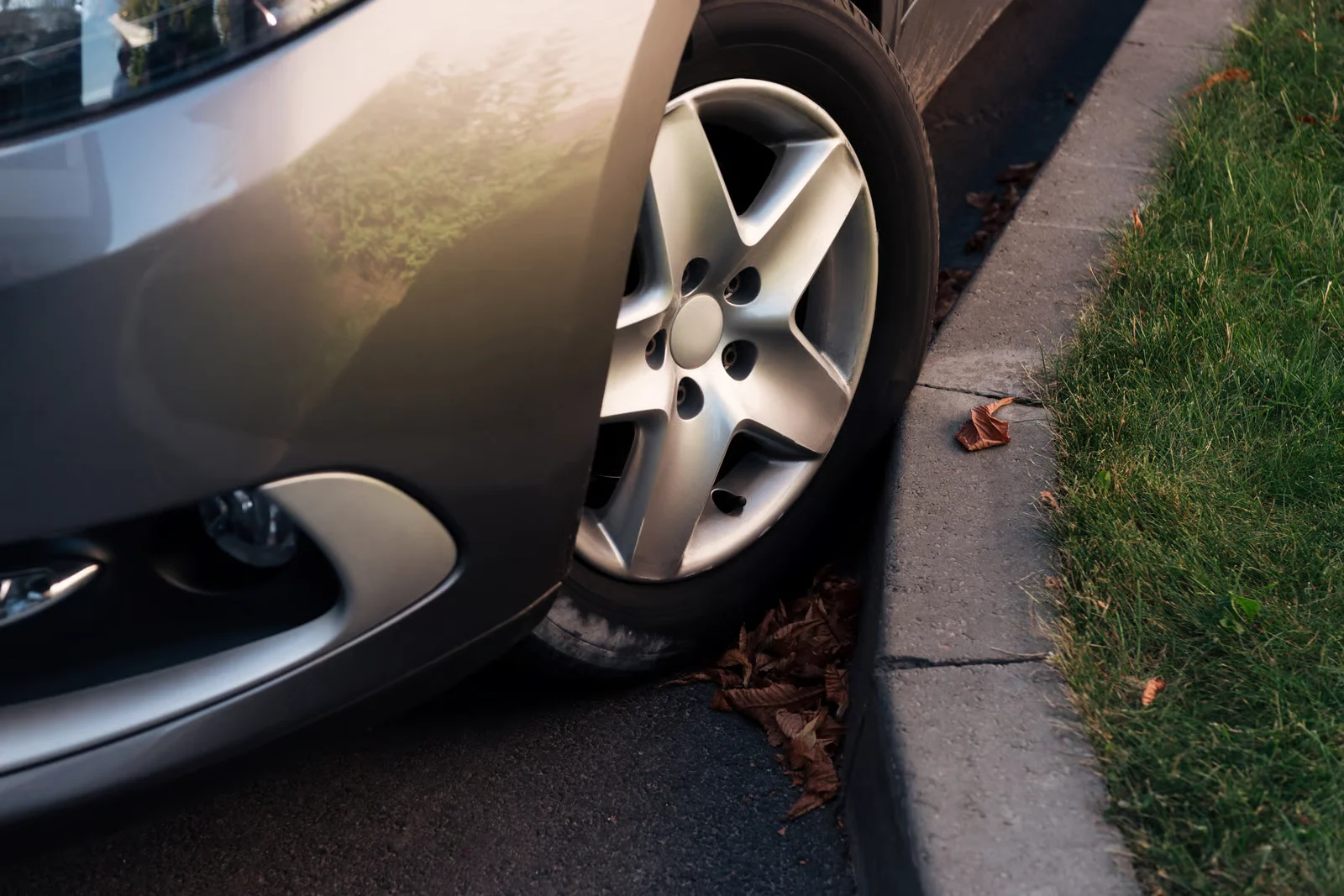 car wheel and rim rubbing against the curb and getting curb rash