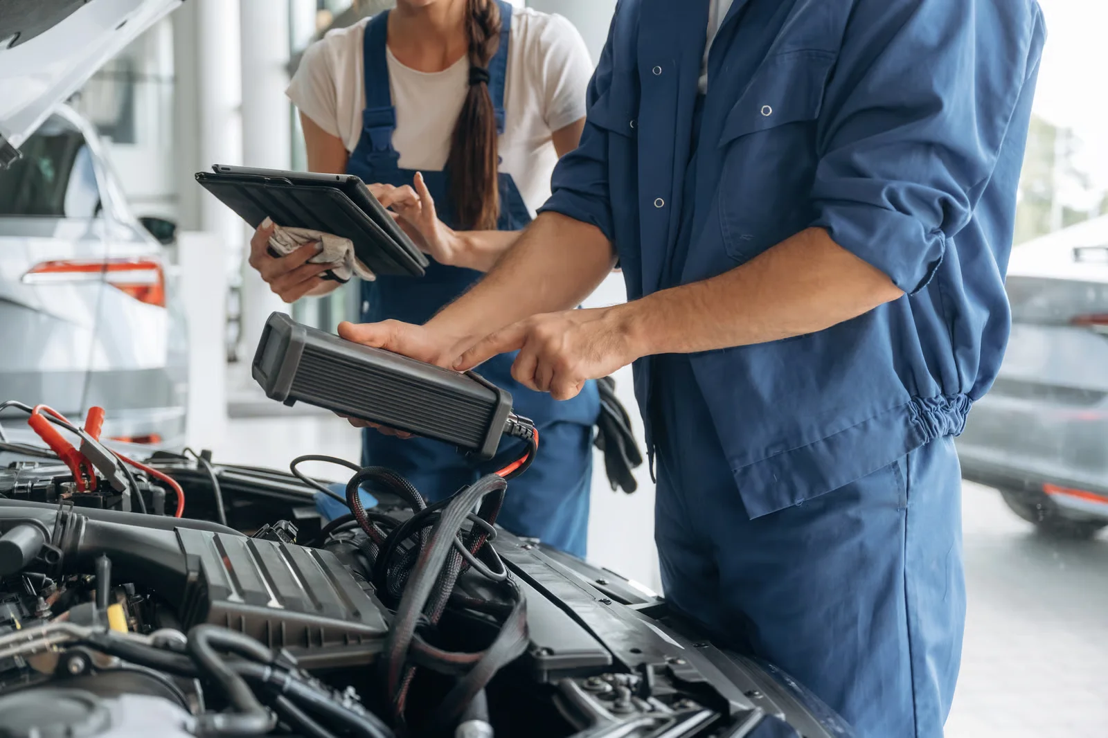 male and female mechanics that are repairing the car
