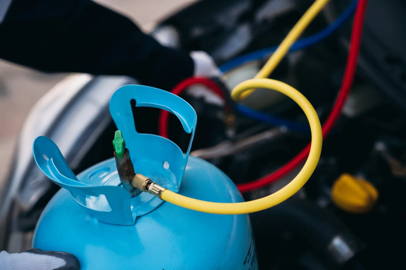 close up hand of mechanics inspect and check the refrigerant and fill the car air conditioner.