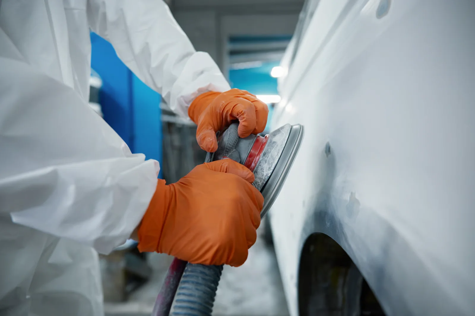 automotive professional using orbital sander on a vehicle