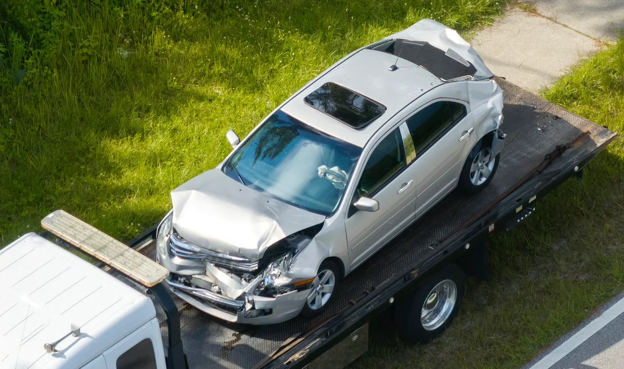 damaged car on tow truck after accident