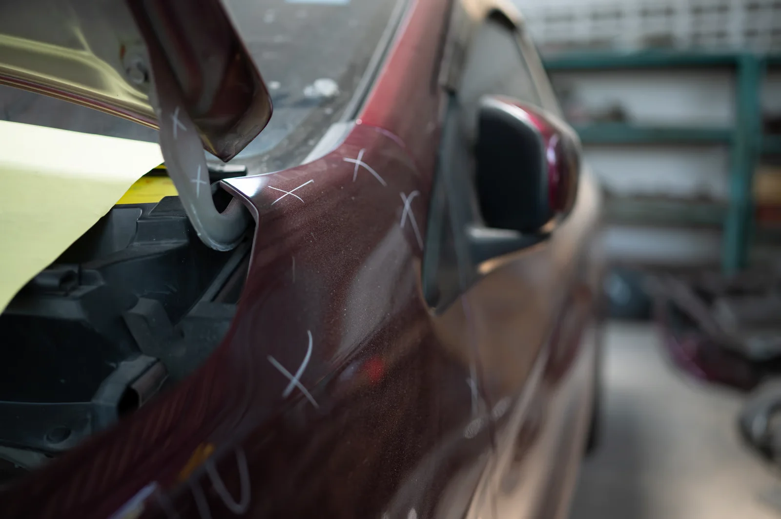 damaged car bodywork marked for repair in garage