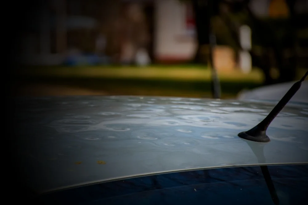 roof of a car heavily dented from hail