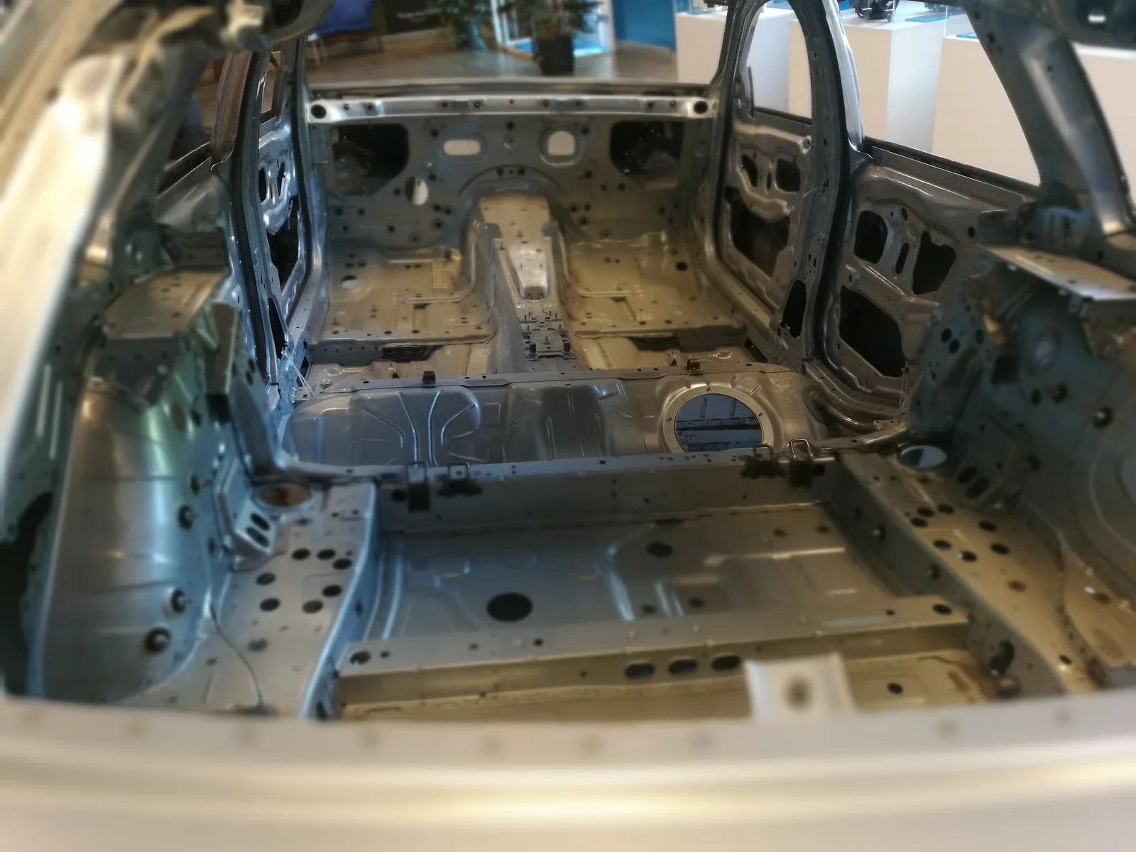 stripped metal car body in factory setting