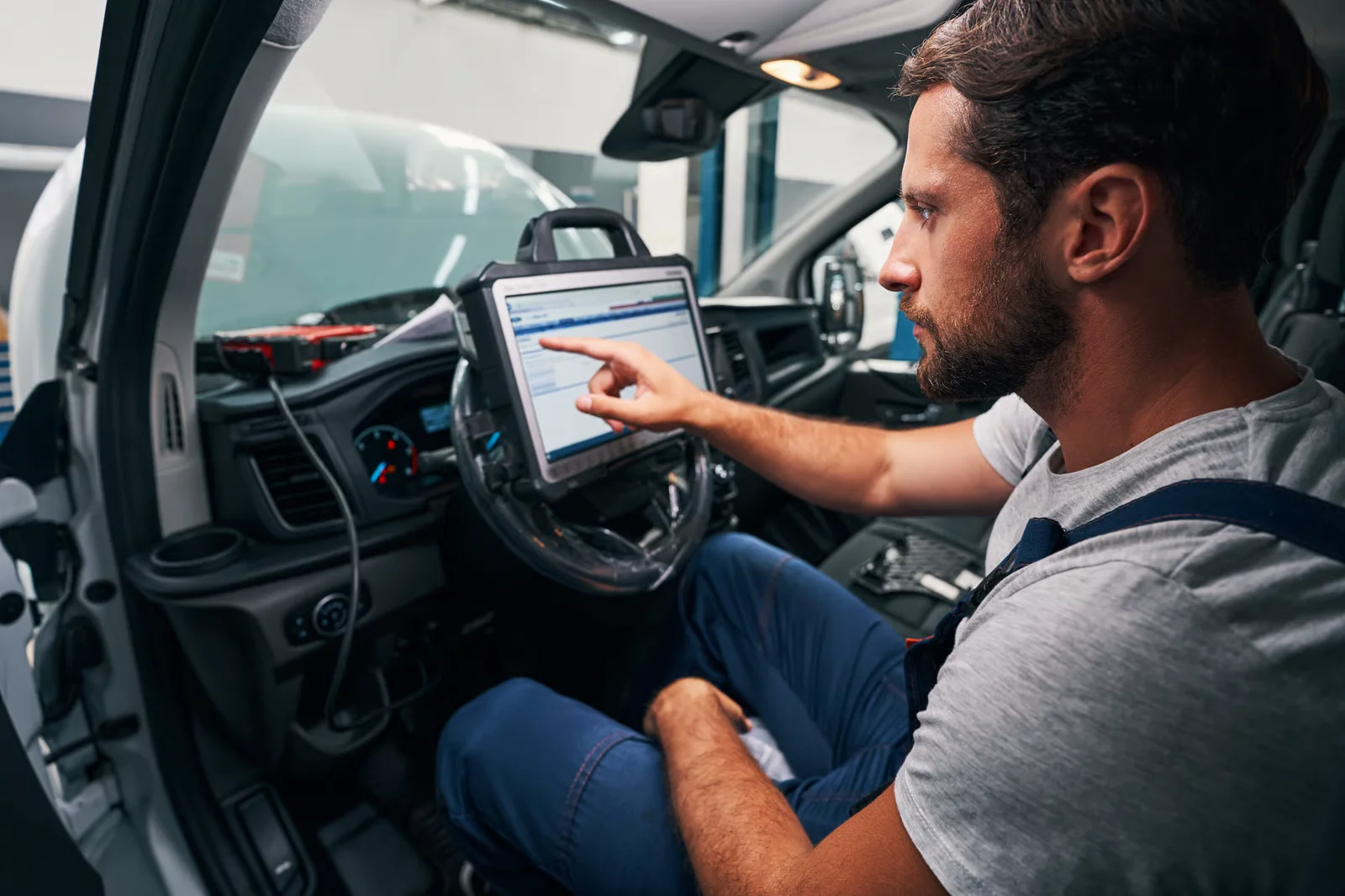 mechanic using tablet inside of van for inspection