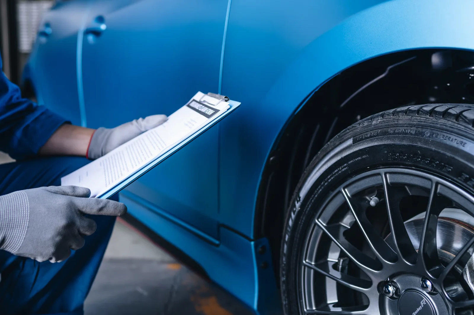maintenance worker checking tire service via insurance system at garage